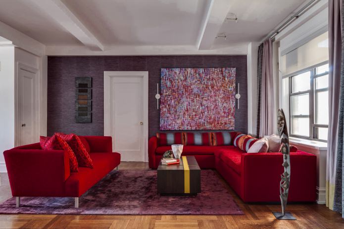 фиолетовые обои и красный тканевый диван