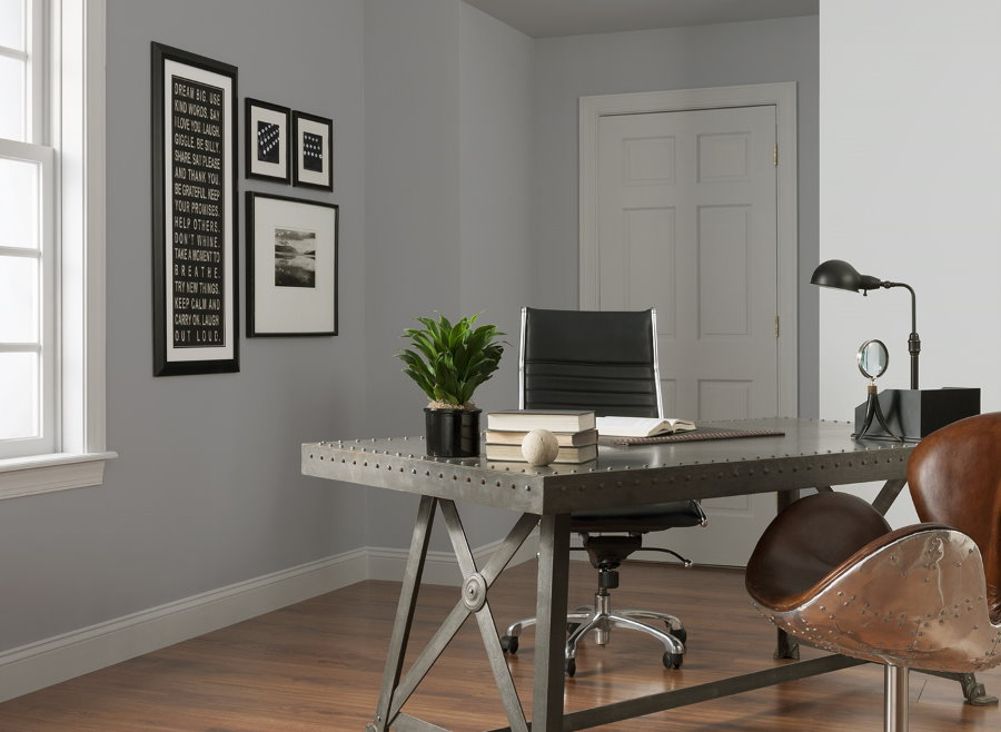 Металлический стол в домашнем кабинет с серыми стенами