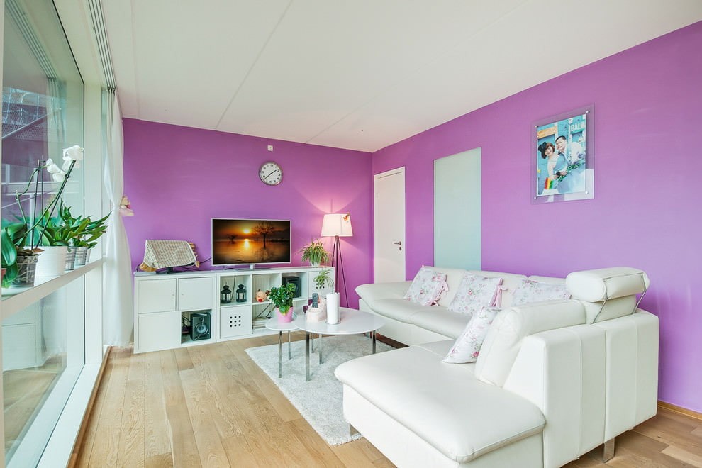 Белый угловой диван у светло-фиолетовой стены