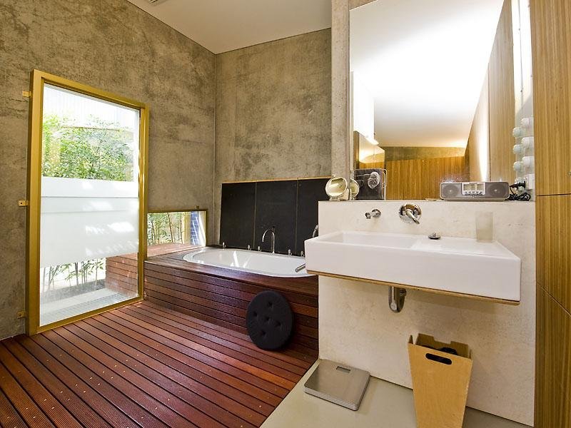 Бежевые бетонные стены в интерьере ванной комнаты