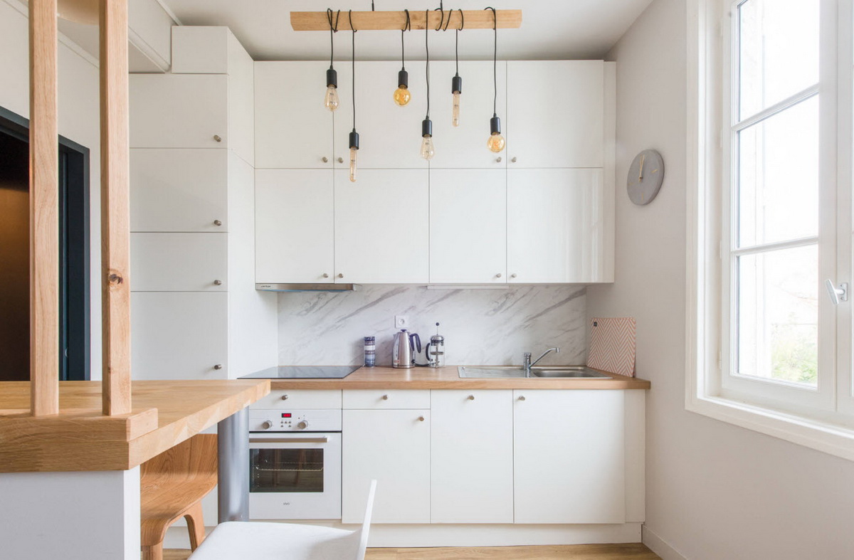 Белая кухня с деревянной столешницей и мраморным фартуком