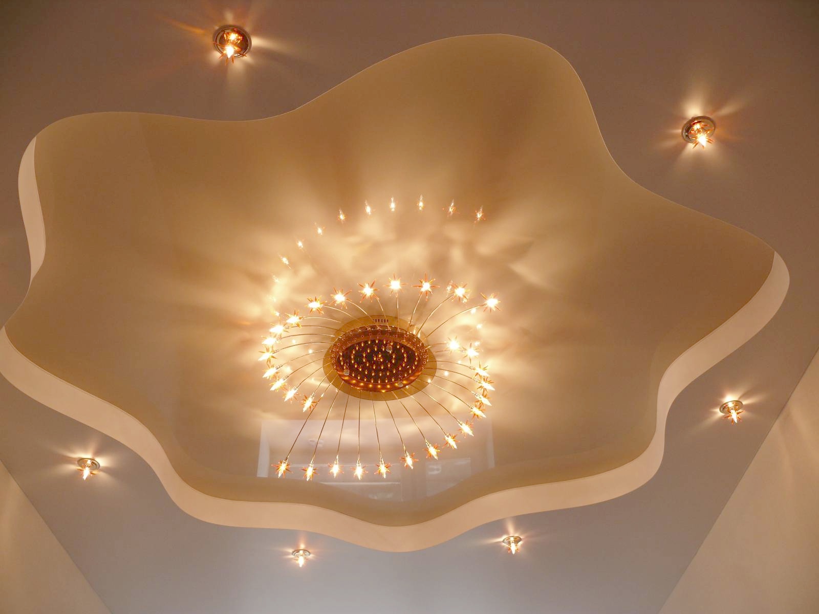 Красивый потолок из гипсокартона и натяжного потолка с люстрой и точечными светильниками