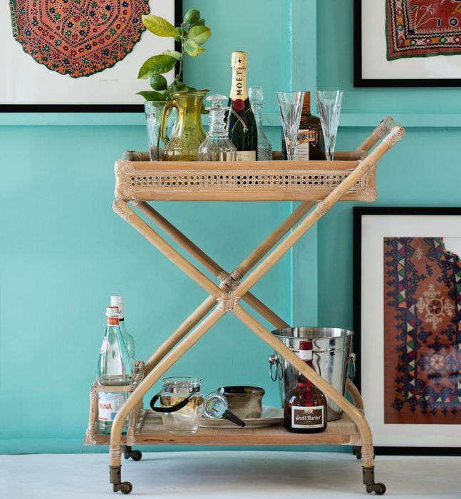 Сервировочный деревянный столик на фоне стены мятного цвета